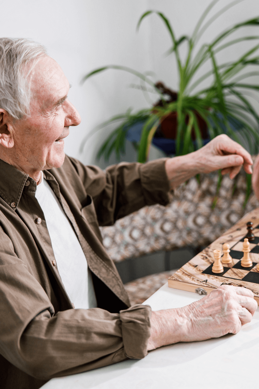 older man playing chess and laughing